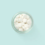 Eco-friendly toothpaste tablets in a zero-waste jar with whitening and plaque-removing ingredients